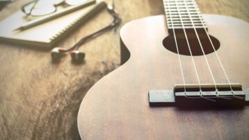 Wooden ukulele on a table representing a beginner’s guide to learning the ukulele