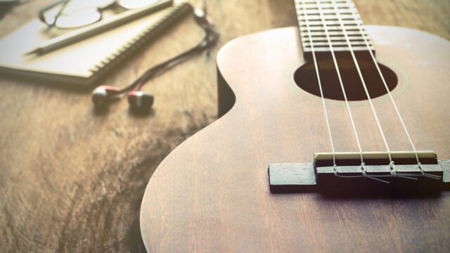 Wooden ukulele on a table representing a beginner’s guide to learning the ukulele