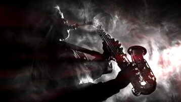 Silhouette of a saxophone player in a smoky atmosphere, representing iconic non-guitar solos in music