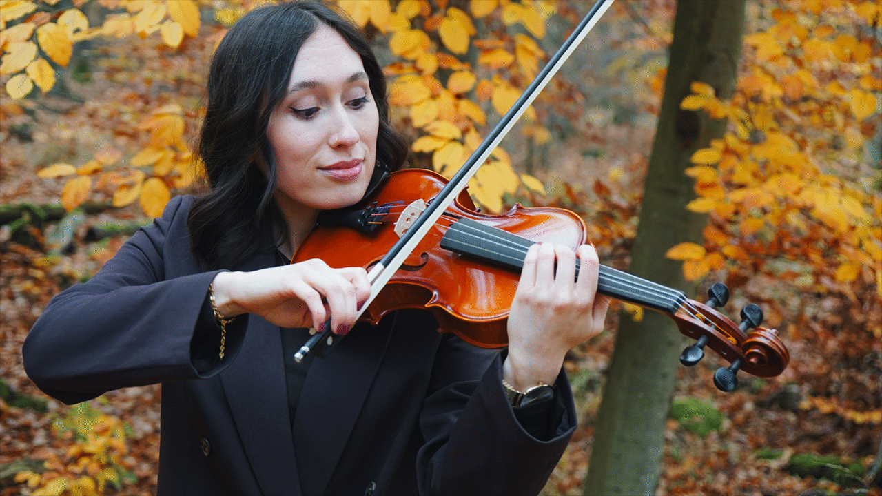violin player practicing outdoors in autumn, demonstrating proper bowing and hand position for string instruments