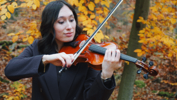 violin player practicing outdoors in autumn, demonstrating proper bowing and hand position for string instruments