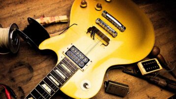 Electric guitar with exposed pickup cavity and replacement humbucker pickups during an electric guitar pickup installation.