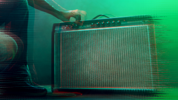 Person adjusting knobs on a guitar amplifier with green stage lighting, illustrating amp noise troubleshooting.