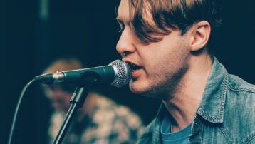 Close-up of male singer warming up vocals into a microphone. Is a Vocal Warm-up Really Necessary? Tips for Singers