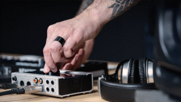 Audio interface on a desk with studio monitors and headphones for music recording and production