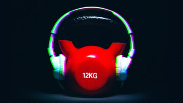 Headphones on a kettlebell symbolising the benefits of listening to music during exercise and strength training