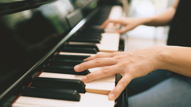 Close-up of hands playing piano keys, illustrating how learning piano is easy and accessible for beginners and adults