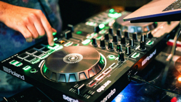 Beginner using a DJ controller with jog wheels and performance pads for mixing music