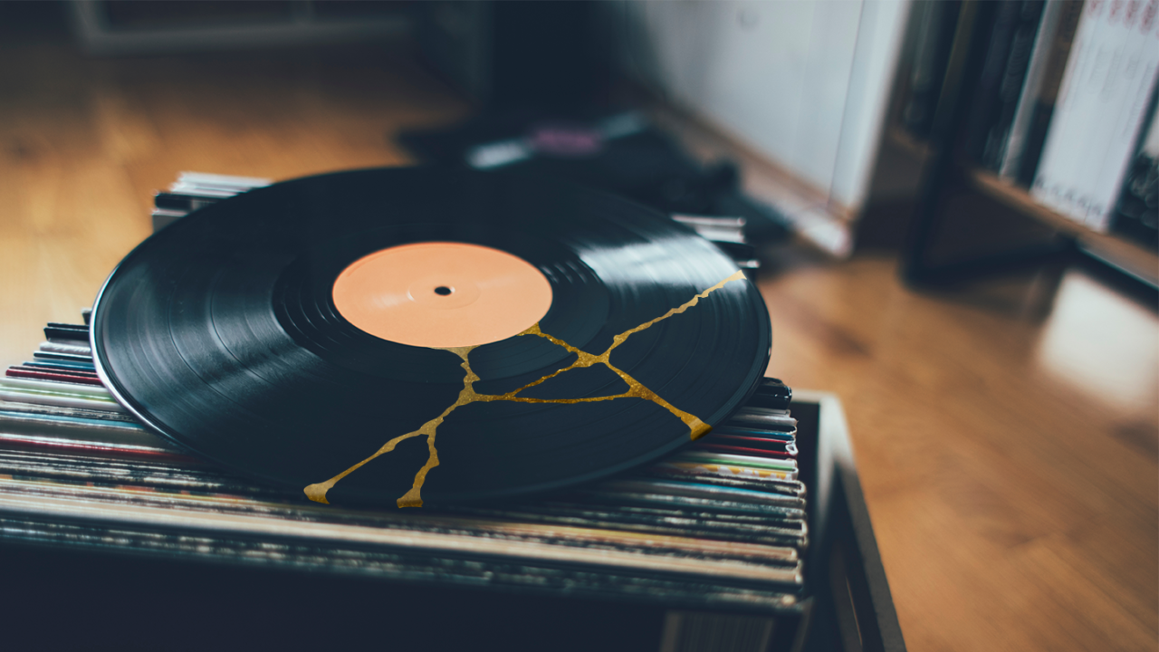 Cracked vinyl record with gold-filled imperfections representing mistakes in famous songs