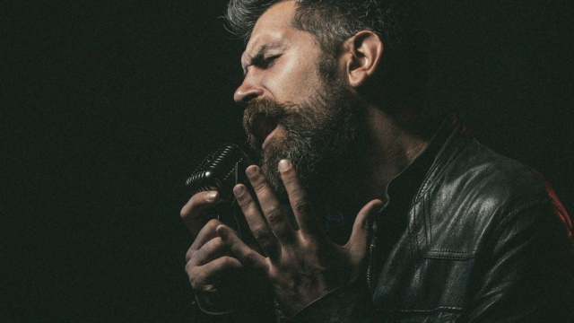 Male singer performing passionately into a vintage microphone